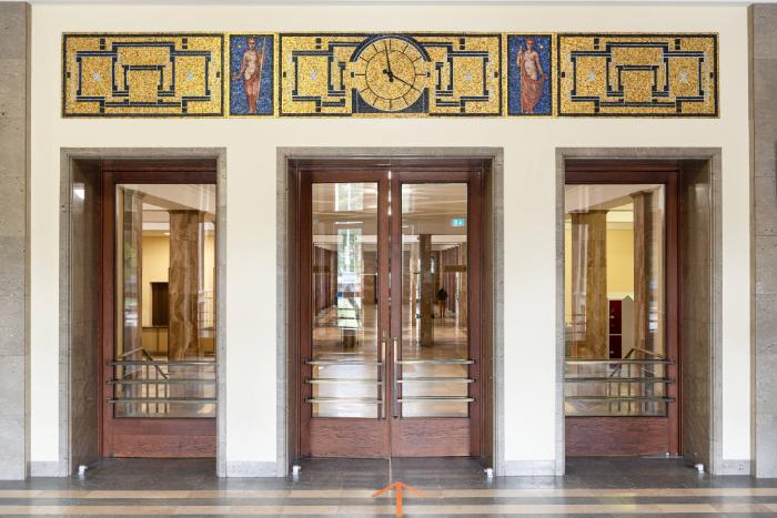 Zwei allegorische, weibliche Figuren mit Uhr