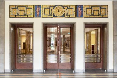 Zwei allegorische, weibliche Figuren mit Uhr