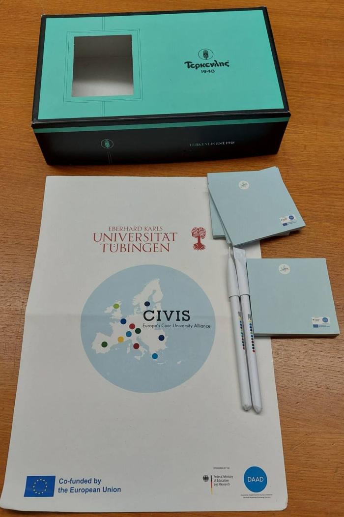 Leere Keksschachtel mit Kugelschreiber, Notizblöcken und Deckblatt mit CIVIS Aufdruck